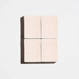 Four square rose-pink natural soap bars arranged in a 2x2 grid on a light background
