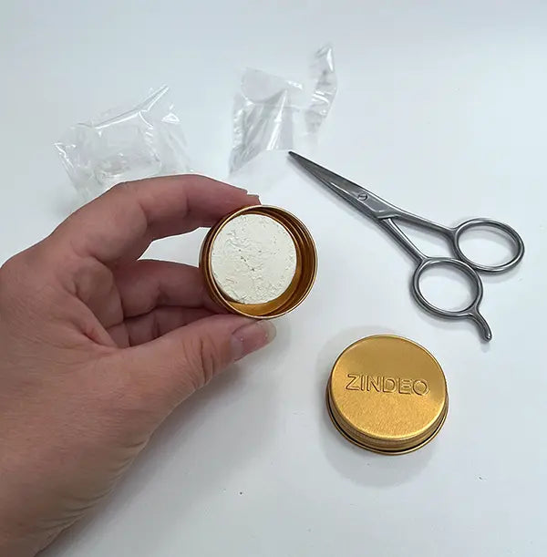 Lata dourada ZINDEO aberta com uma nova recarga de Anti-odorant Cream no interior