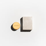 Anti-odrant cream with gold cap and salt soap on a light gray background